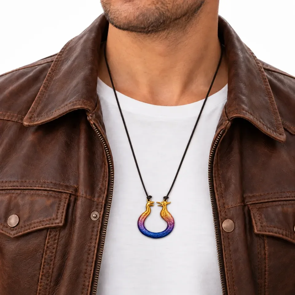 Pingente num cordão preto, usado sobre camiseta branca e jaqueta de couro marrom.